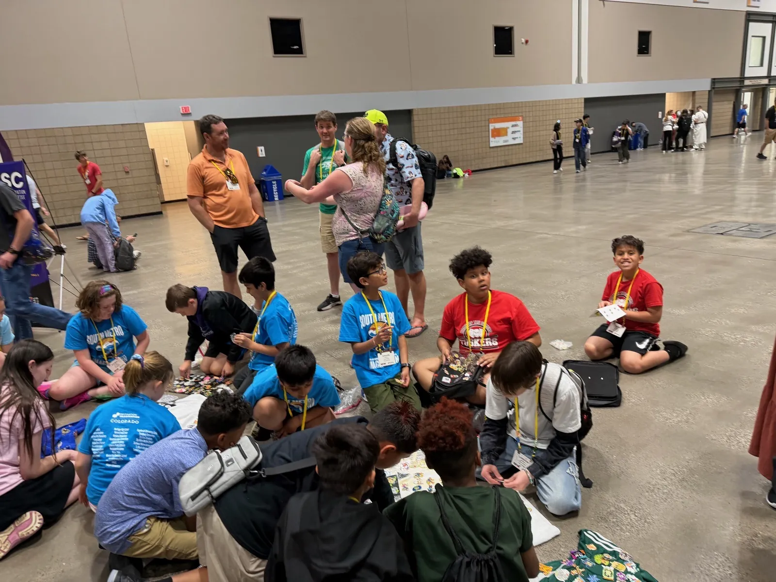Fig. 15 — Sitting on the floor trading pins with kids from other teams